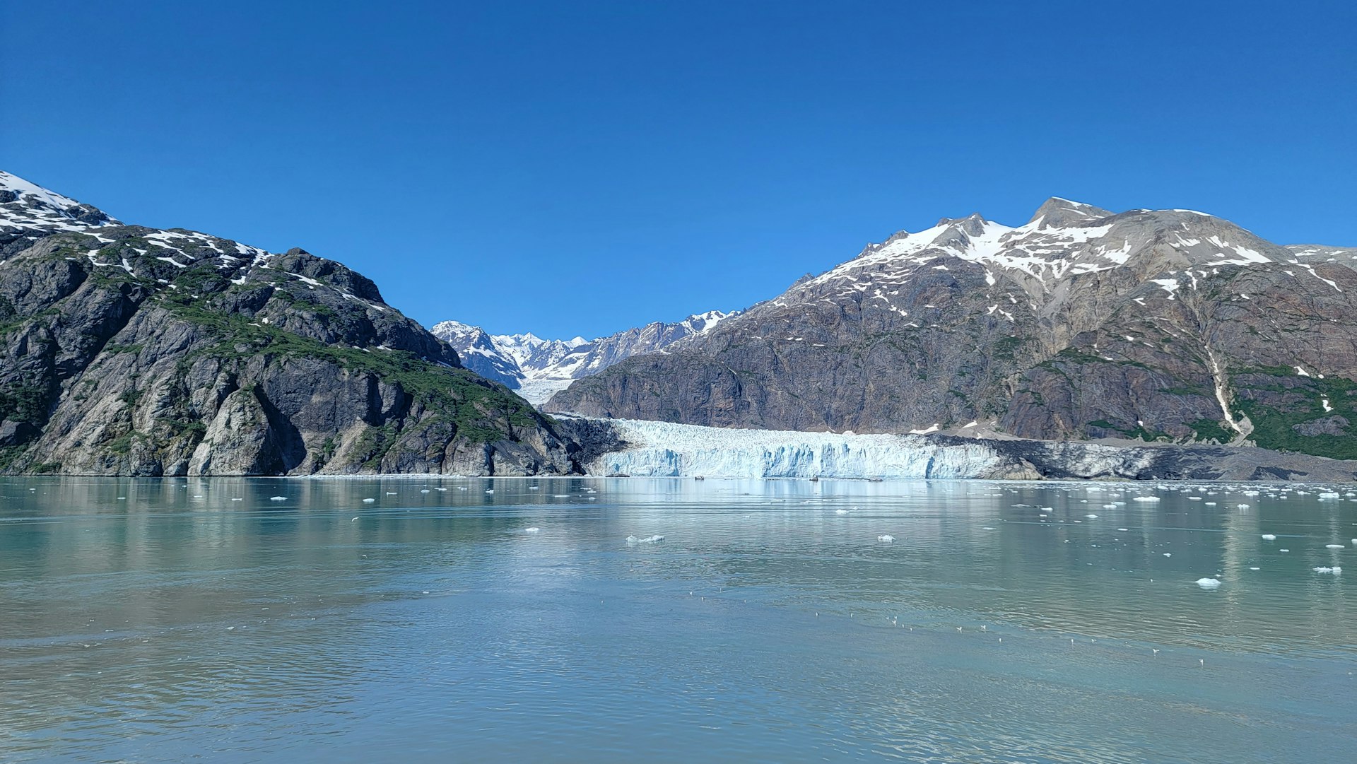a large glacier with mountains in the background